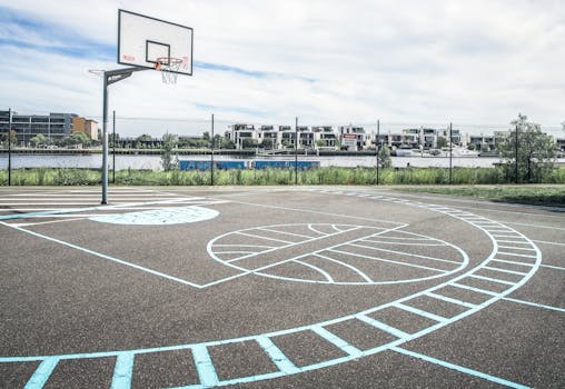 Empty basketball court in a Melbourne park with city skyline in the background.