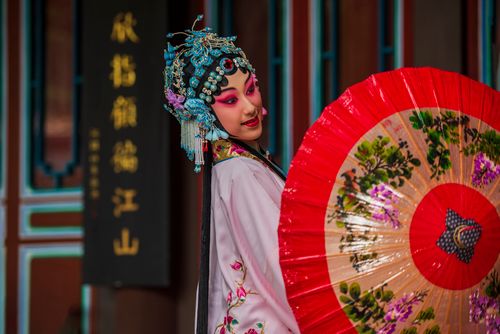 Free Portrait of a woman in traditional Chinese opera attire with an ornate umbrella, showcasing cultural elegance. Stock Photo