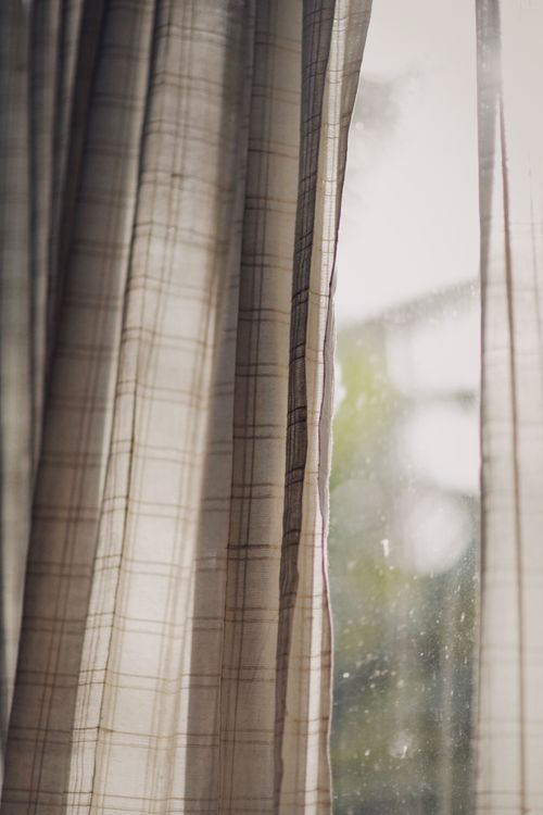 Free Elegant checkered curtains filtering soft daylight in a serene indoor setting. Stock Photo