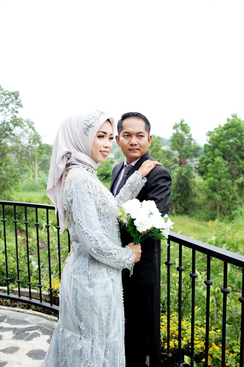 Bride in Traditional Wedding Dress standing beside her Groom 
