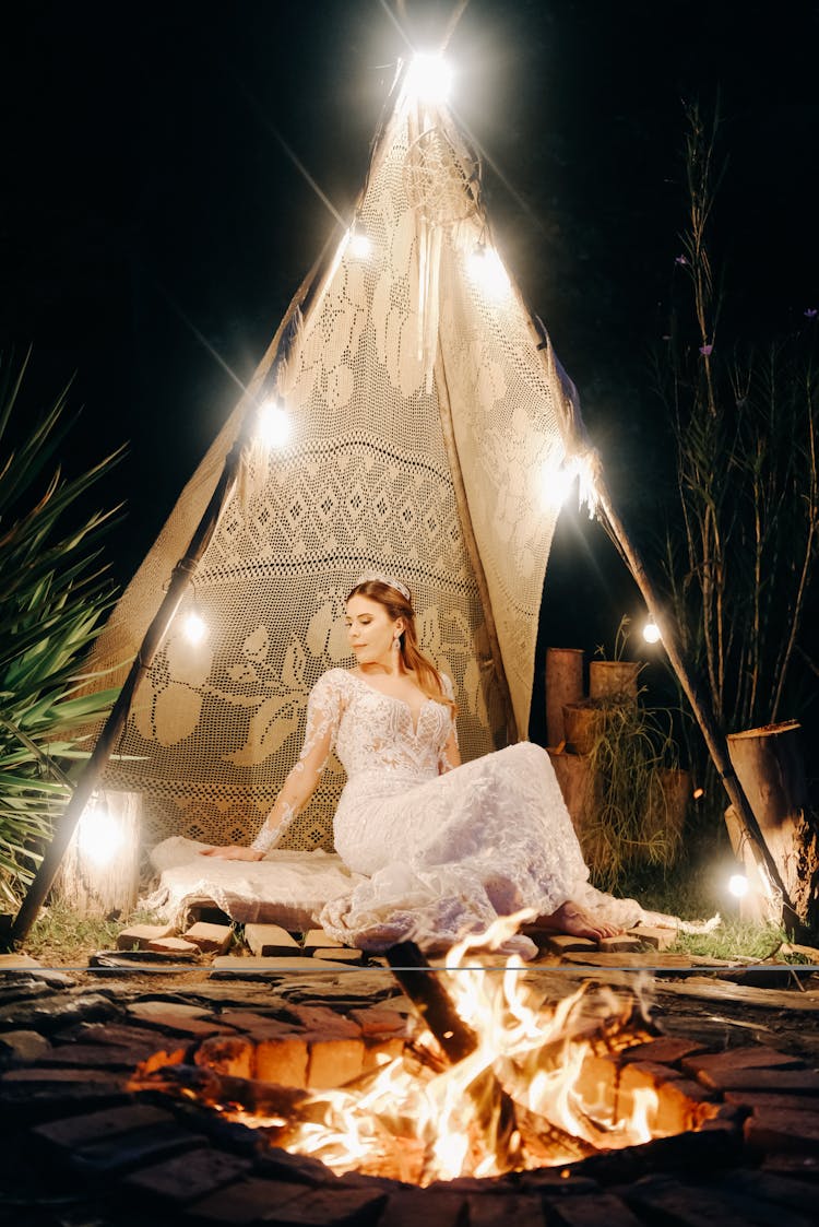 Woman Sitting In Tipi Behind Bonfire