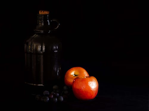 Free stock photo of apples, black background, gallon jug