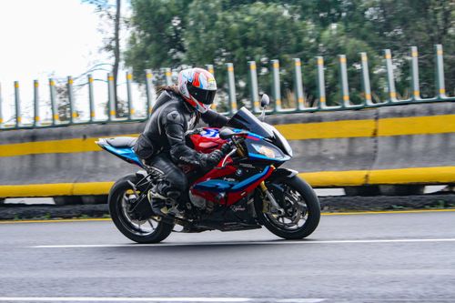 Free A biker in protective gear rides a sleek motorcycle on a city road. Stock Photo