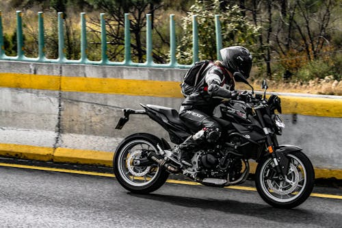 Person in Black Helmet Riding Black Motorcycle