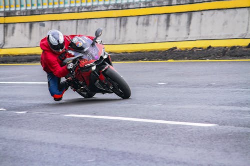 A Person on a Motorcycle Banking on Asphalt Road