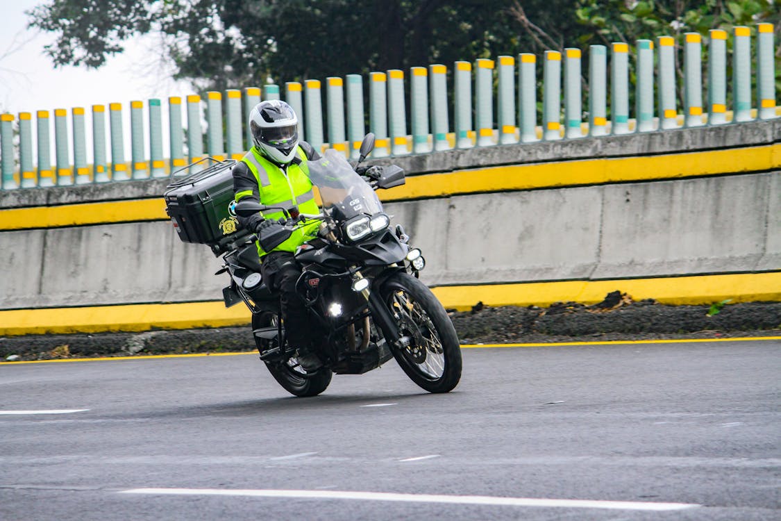 Person Wearing Safety Vest Riding a Motorcycle