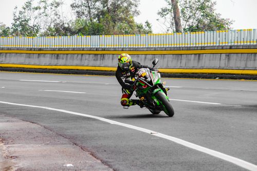 Free Dynamic shot of a motorcyclist racing through a curve on a road track. Stock Photo