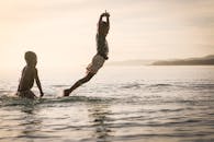 两个孩子在海边戏水玩耍，享受夏日时光