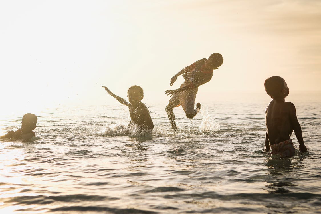 бесплатная 4 человека играют в океане днем Стоковое фото