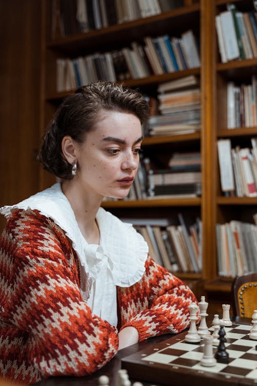 Pensive Woman looking at a Chess Set