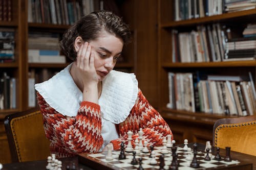Free Pensive Woman looking at a Chess Set Stock Photo