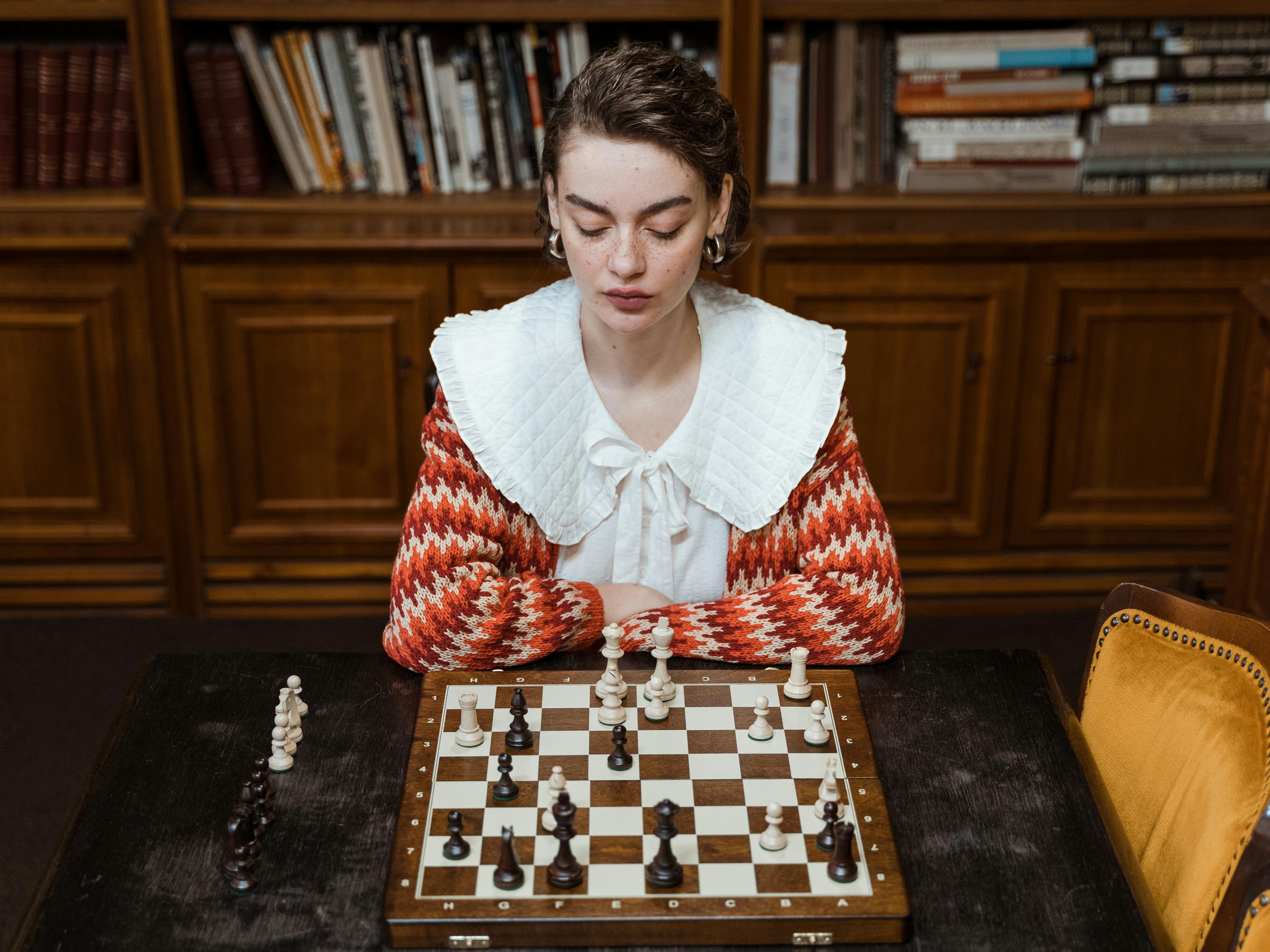 focused woman looking at a chess game