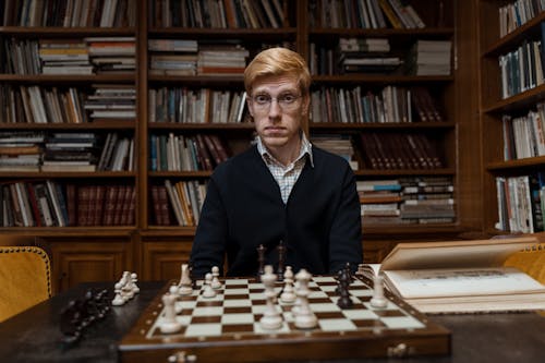 Man sitting in front of a Chess Board 