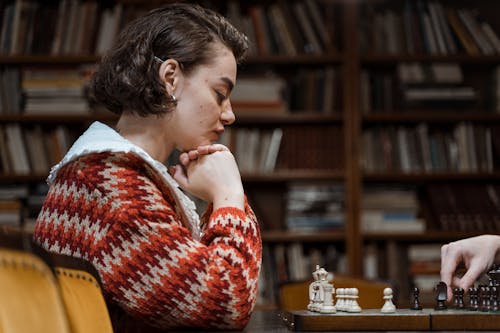 Free Pensive Woman looking at a Chess Game  Stock Photo