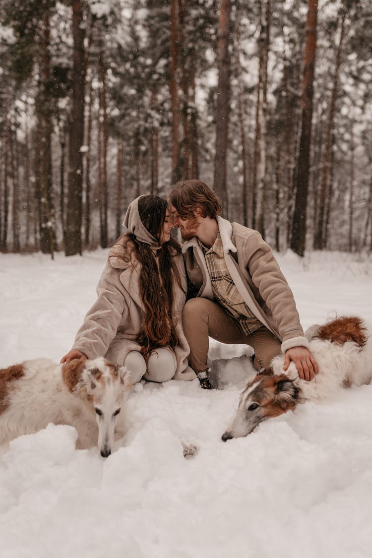 A Romantic Couple With Their Pets In The Snow