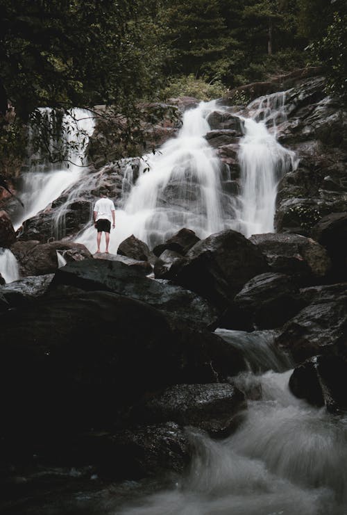 Person standing in a Boulder near Waterfalls 