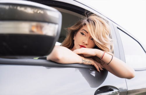 Woman in Sweater Sitting Inside Car Looking Out the Window · Free Stock ...