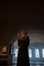 Elderly Woman holding a Lighted Candle