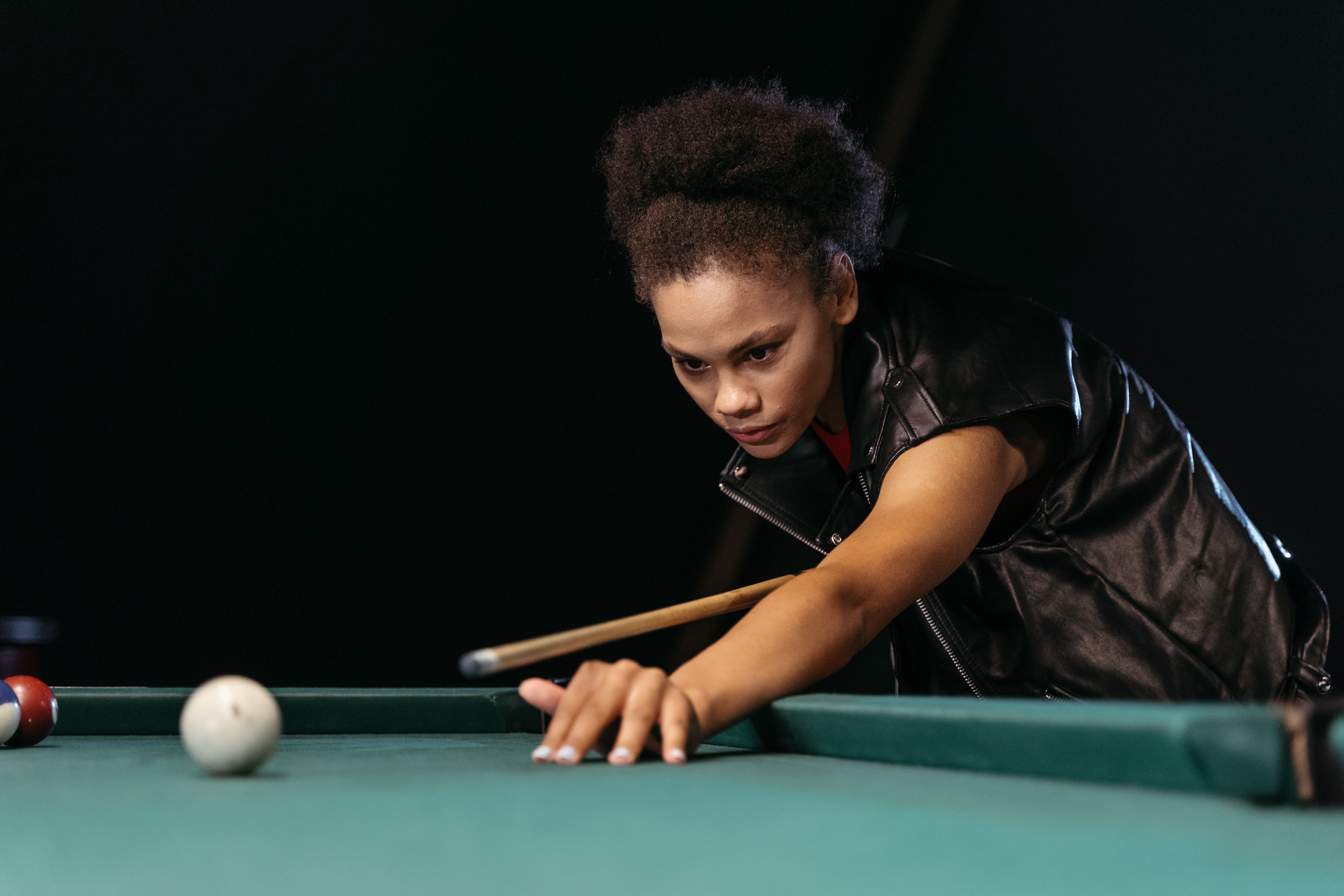 woman with afro hair playing billiards