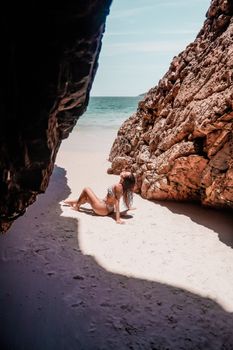 Woman on a sandy beach by rock formations in Arraial do Cabo, Brazil, enjoying the sun.
