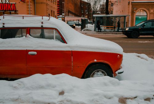 Free A red vintage car covered in snow, parked on a snowy street in St. Petersburg, Russia. Stock Photo