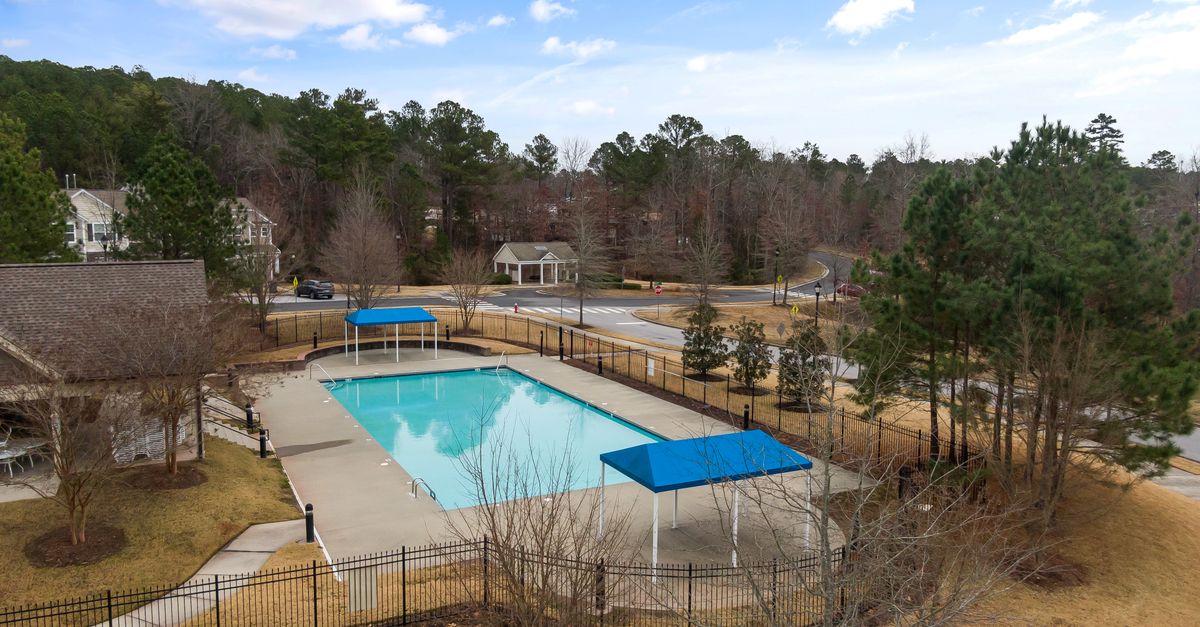 Aerial view of a community swimming pool with trees and houses in Morrisville, NC.