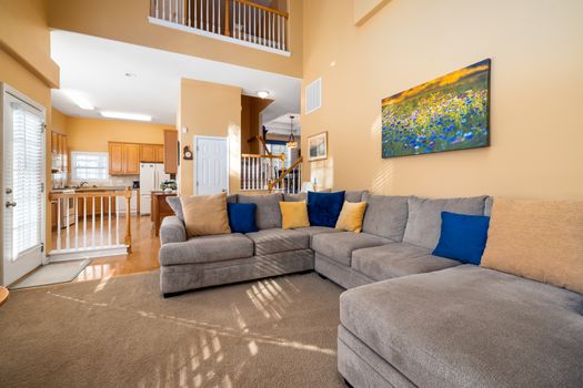 Bright and spacious living room showcasing a cozy grey sofa and modern interior design.