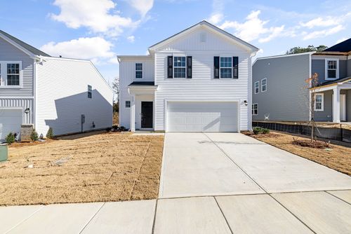 Free Contemporary white house with garage, blue sky, and landscaped yard. Stock Photo