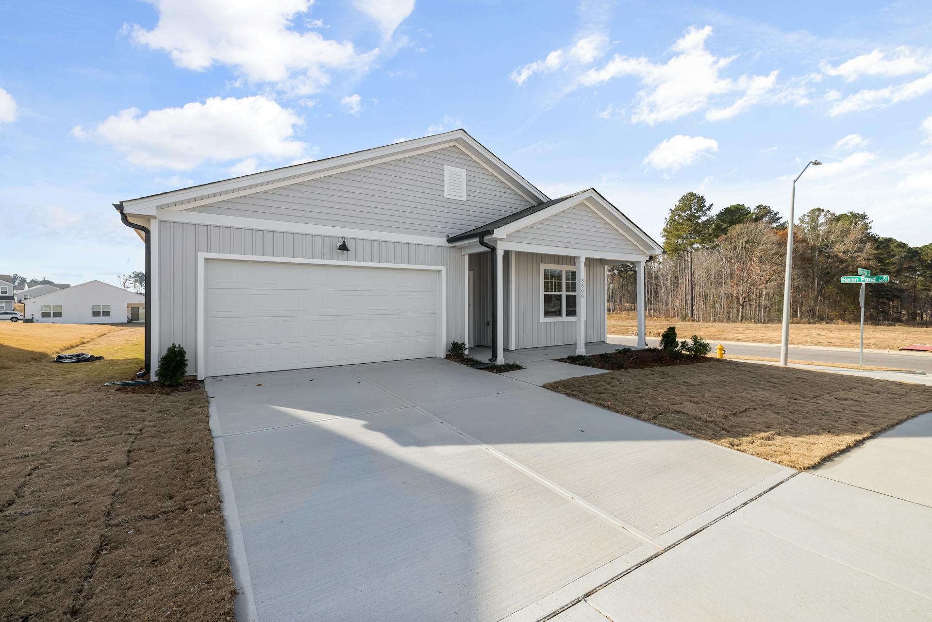 Beautiful modern suburban home with a spacious driveway under a clear blue sky.