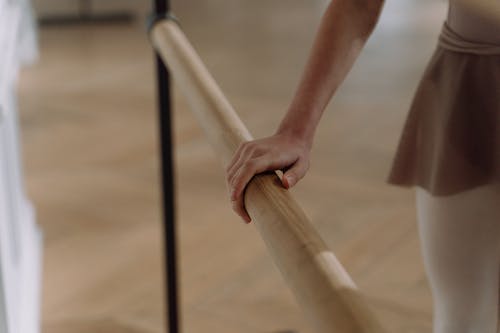 Close-up Photo of Hand holding in a Wooden Handrail 