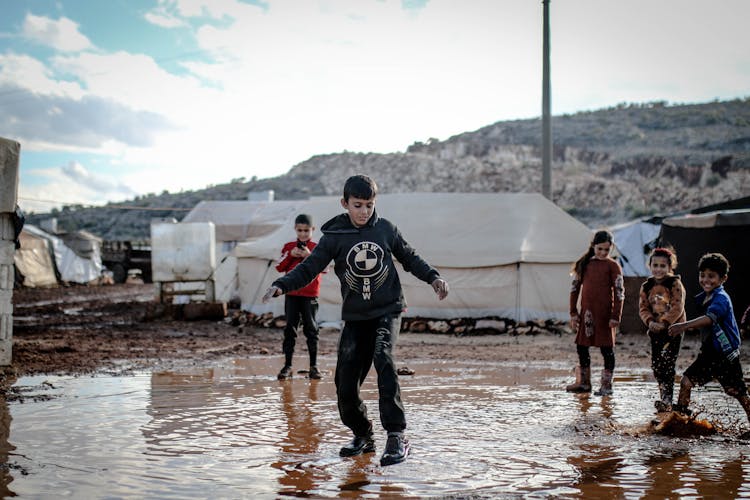 Kids Playing In Puddle