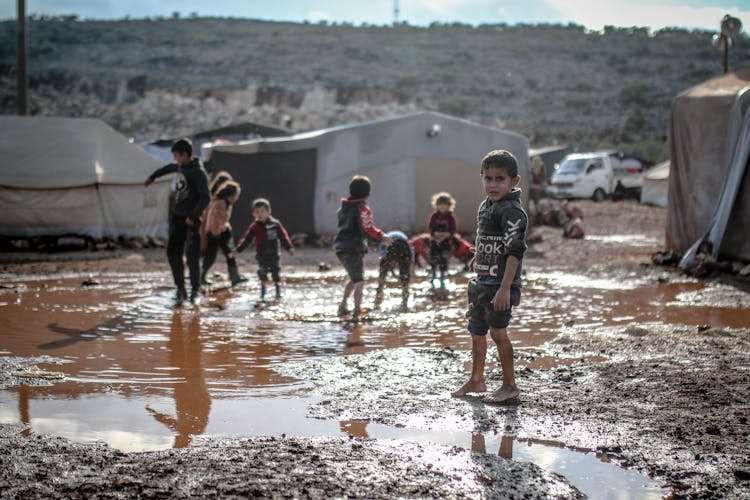 Kids Splashing Water In Puddle