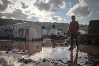 Boy in Red Jacket standing in a Muddy Ground
