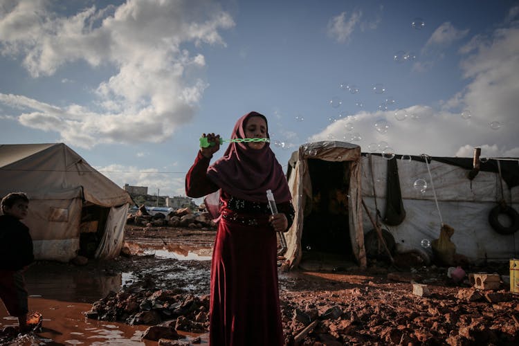 Portrait Of Woman In Hijab Making Soap Bubbles