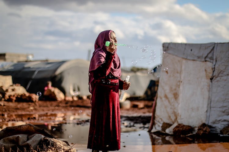 Woman In Hijab Making Soap Bubbles