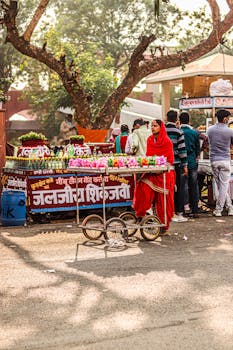 Vibrant street market with a woman in red selling flowers and goods.