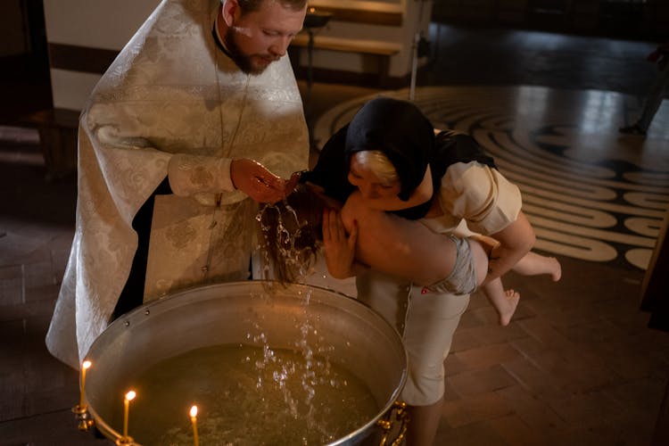 A Bishop Baptising A Kid 