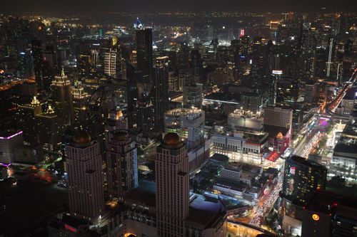 Free Explore the bustling city lights of Bangkok in this captivating nighttime aerial view of the urban skyline. Stock Photo