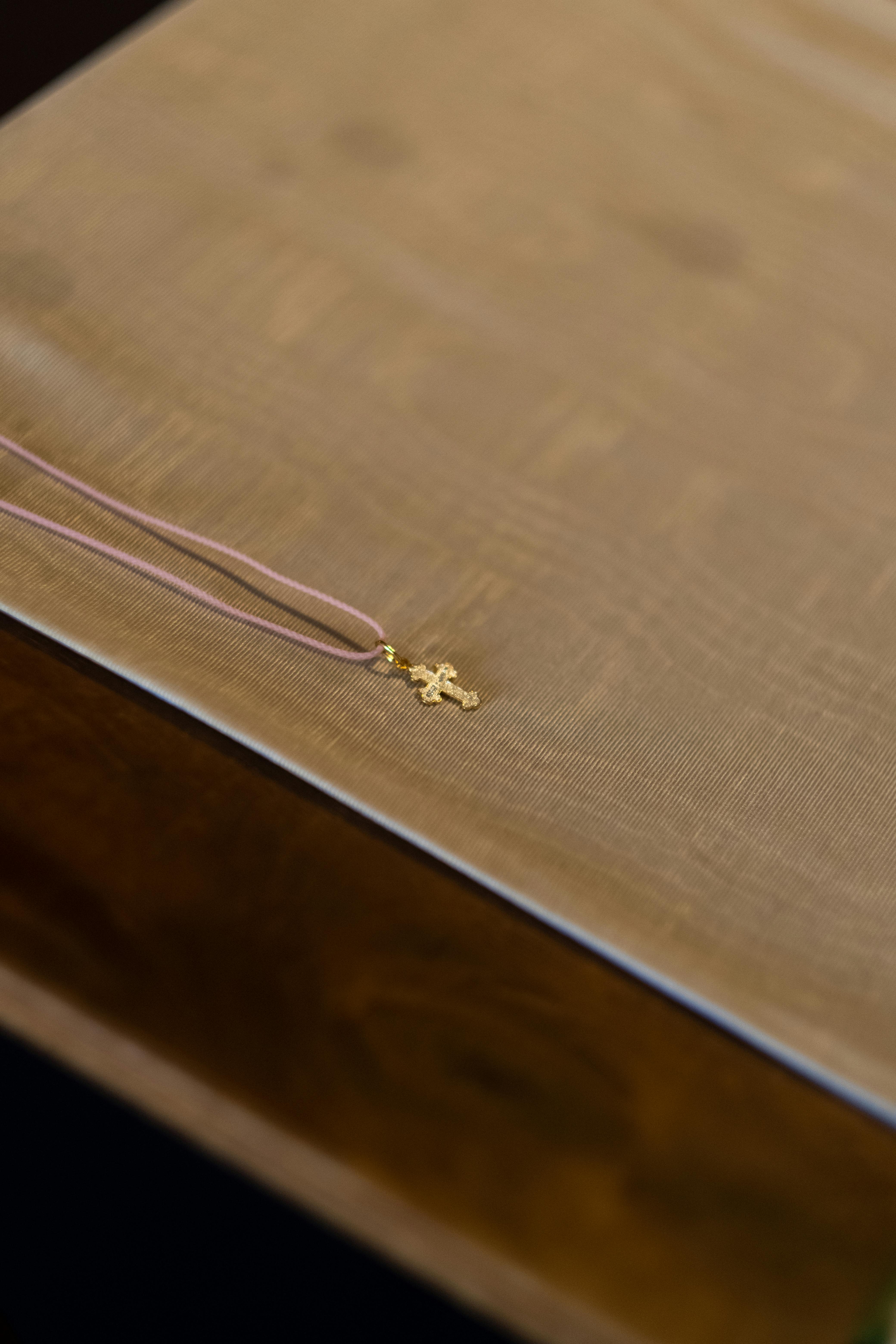 close up of small gold cross on string in orthodox church