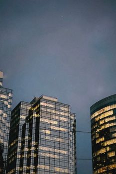 High-rise glass buildings towering under an evening sky, showcasing urban architecture.