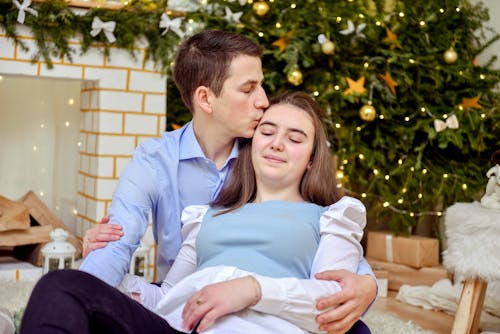 Man in Blue Long Sleeve Shirt Kissing a Woman