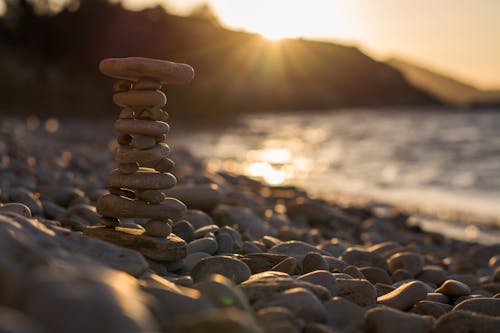 Stack of Stones on the Shore of the Beach during Sunset