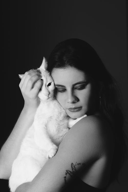 Grayscale Photo of Woman Hugging Cat