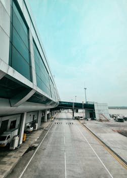 Spacious and modern airport terminal in Jakarta with a clear blue sky and empty road.