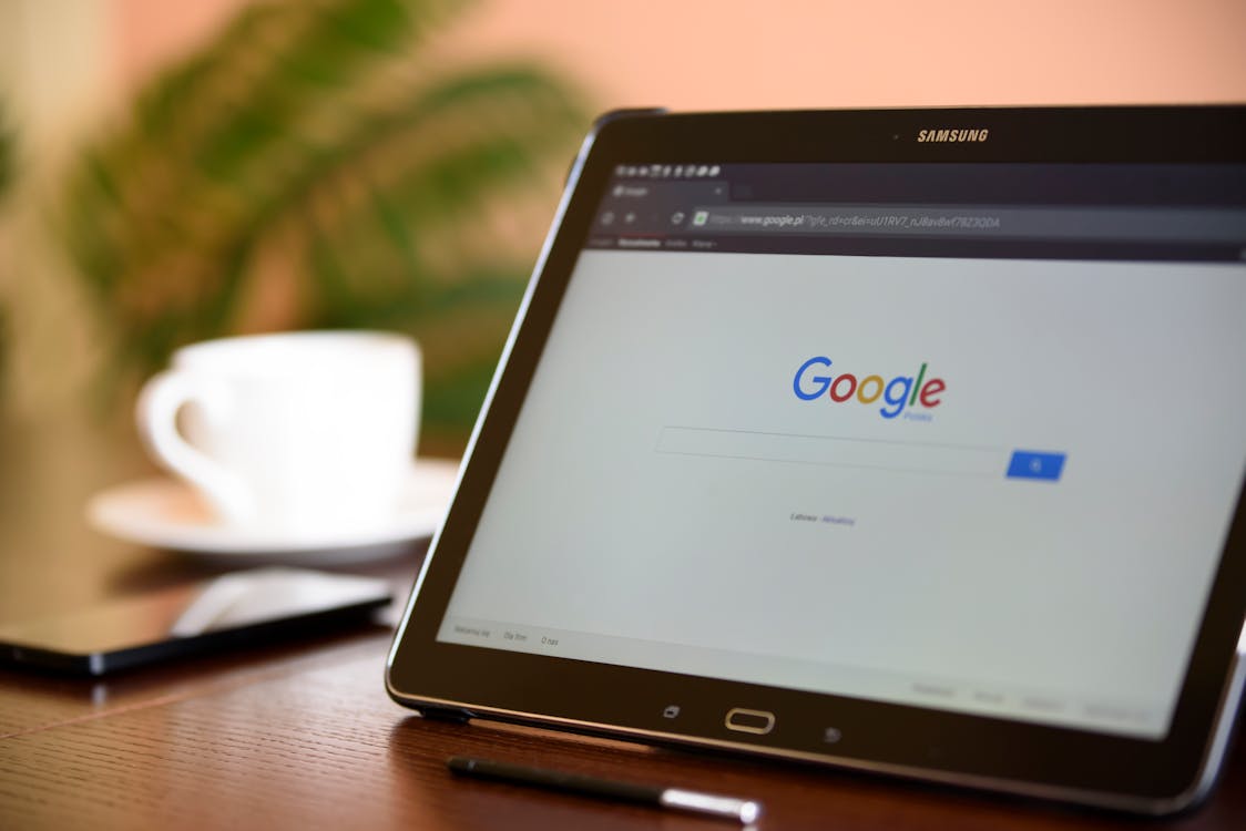 An image of a samsung tablet with the Google homescreen on the screen. 