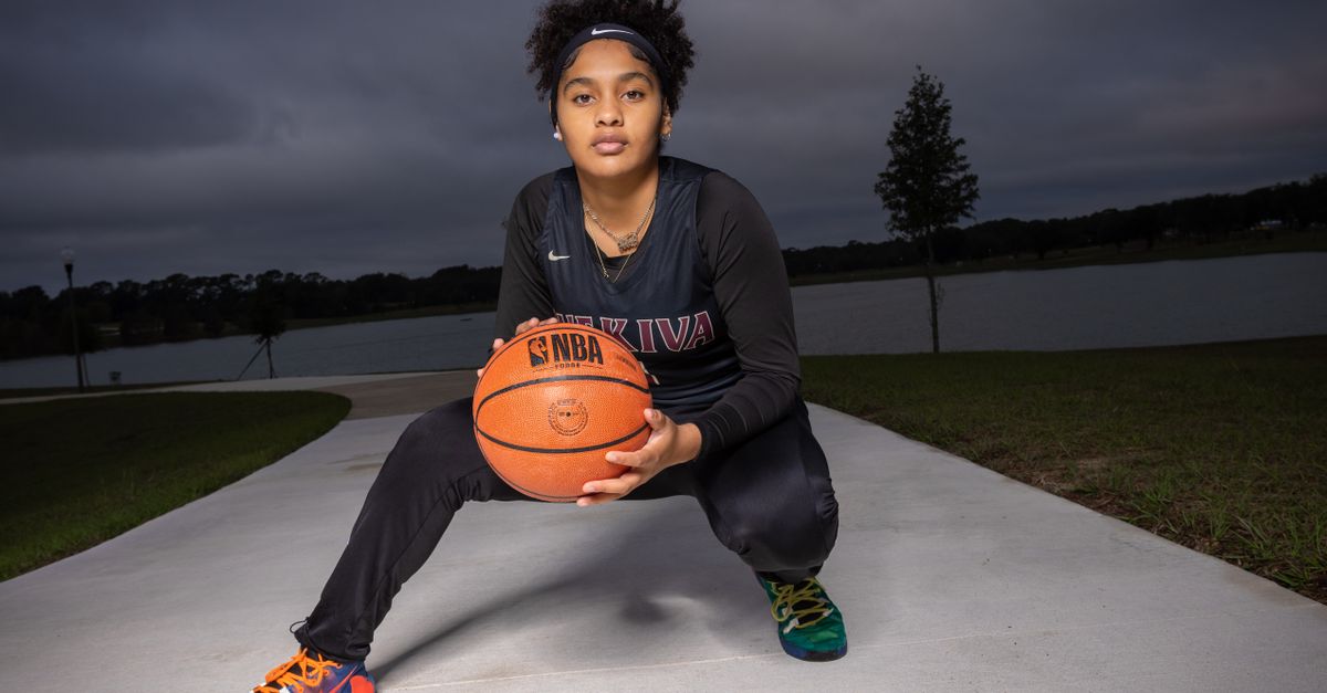 Teen athlete holding a basketball outdoors, showcasing sportsmanship and determination.
