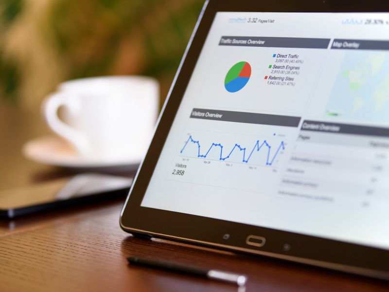 Tablet displaying marketing charts on a clean desk with a smartphone