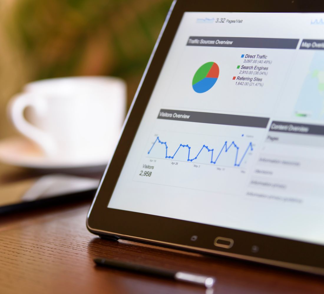 A tablet showing a marketing dashboard beside a coffee cup