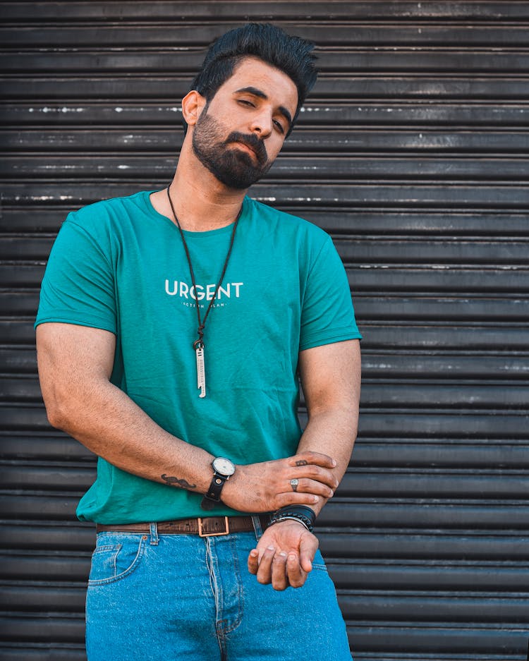 Brunette Man In Turquoise T-Shirt Standing By A Shutter