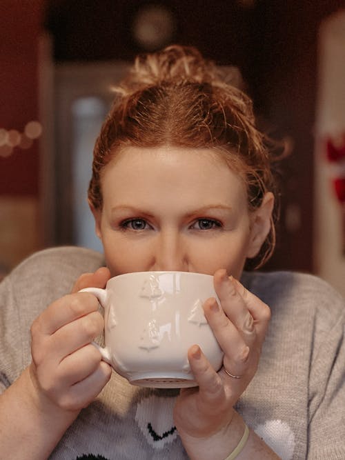 Girl in Gray Sweater Holding White Ceramic Teacup